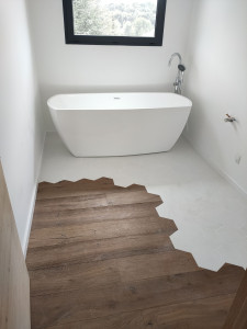Photo de galerie - Mélange des matières pour cette salle de bain 
carrelage exagonal et parquet massif