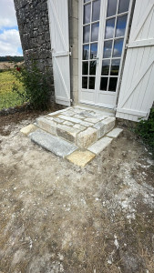 Photo de galerie - Réalisation d’un escalier extérieur en pierre naturelle, avec pose des marches et jointoiement. Travail soigné pour un rendu authentique et harmonieux, en accord avec le caractère de la maison.