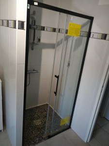 Photo de galerie - Mise en place d'une porte de douche avec partie fixe.