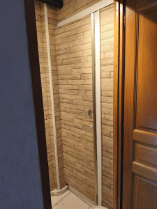 Photo de galerie - Pose d'un papier peint avec raccords imitation bois dans un toilettes.