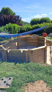 Photo de galerie - Pose en cours d'une piscine semi enterré en bois.