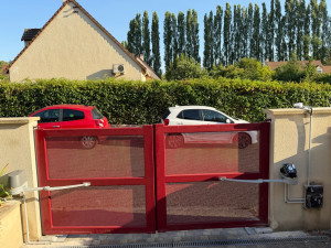 Photo de galerie - Installation et raccordement d’un portail motorisé avec bras articulés, motorisation Somfy et mise en service. Travail soigné et finition propre.