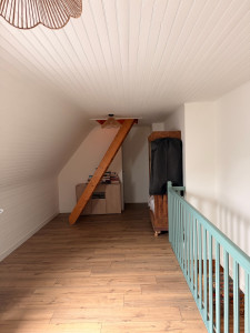 Photo de galerie - Rénovation intérieure d’une pièce sous combles : remise en état des murs (ratissage et peinture), rénovation du lambris par peinture et pose d’un nouveau sol pour un rendu moderne et lumineux.