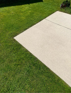 Photo de galerie - Nettoyage Karcher d’une dalle béton avec résultat propre comme neuf. Tonte réalisée avec soin et démarcations nettes entre le béton et la pelouse pour un rendu propre et précis. Travail soigné et finition impeccable, comme visible sur la photo. 