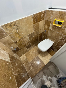 Photo de galerie - Pose carrelage sol et murs (effet pierre) avec WC suspendu. Découpes propres, chantier presque terminé.  Disponible pour tous travaux de carrelage (SDB, WC, sol/mur).
