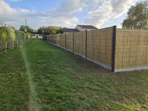 Photo de galerie - Pose de clôture rigide avec occultant bois 
Voici un exemple de réalisation : clôture rigide sur soubassement béton, avec panneaux occultants en bois pour plus d’intimité et d’esthétique.