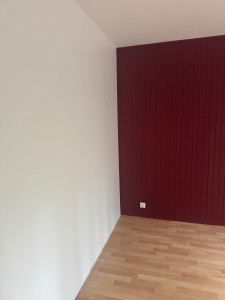 Photo de galerie - Rénovation intérieure avec mise en peinture des murs et pose d’un revêtement mural décoratif à lames verticales, accompagnée de la pose d’un parquet bois pour une finition moderne et soignée.