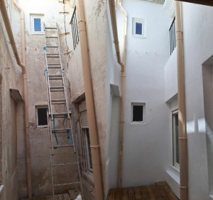 Photo de galerie - Reprise de maçonnerie à certains endroits avec traitement d'une grosse fissure par injection fibré + pose d'agrafe avant application d'un bloqueur de fond et avant mise en peinture de la façade d'une cour.

