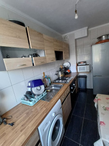 Photo de galerie - Cuisine propre et bien organisée, avec un plan de travail nettoyé, des placards en bois bien entretenus, des appareils en ordre et un sol soigneusement lavé.