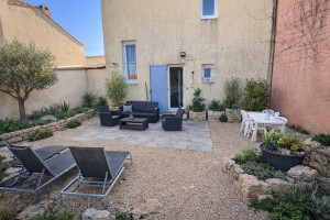 Photo de galerie - Aménagement complet d’une cour initialement en terre nue : terrasse, gravier, massifs en pierre naturelle et plantations méditerranéennes.  Création d’un espace extérieur esthétique, structuré et durable.