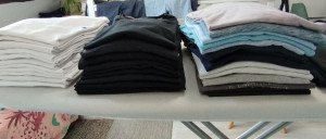 Photo de galerie - Pile de t-shirts repassés et prêts à être rangés 