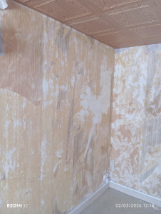 Photo de galerie - Murs avec ancien papier peint et résidus de colle, support abîmé nécessitant une préparation complète.