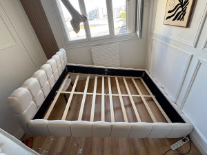 Photo de galerie - Nstallation complète et sécurisée d'un lit coffre design avec structure capitonnée et sommier à lattes.