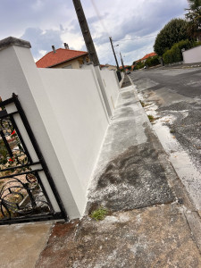 Photo de galerie -     Réalisation complète d’un mur de clôture : maçonnerie, enduit et finitions.