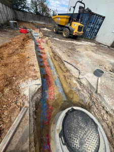 Photo de galerie - Tranché pour eau potable avec un câble électrique protégé par une  gaine avec leur grillage avertisseur,un assainissement raccordé dans une création de regard .
