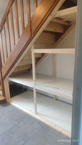 Photo de galerie - Aménagement de l'espace sous l'escalier en zone de rangement.