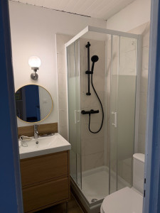 Photo de galerie - Pose d’une cabine de douche complète avec robinetterie, meuble vasque, lavabo et raccordement de l’évacuation, réalisée avec soin et finitions propres.