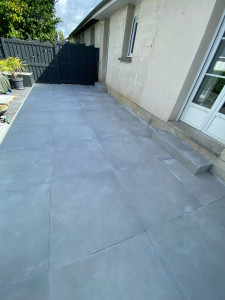 Photo de galerie - Pose de carrelage extérieur 90x90 sur terrasse. Préparation du support, pose collée, joints et finitions soignées.
