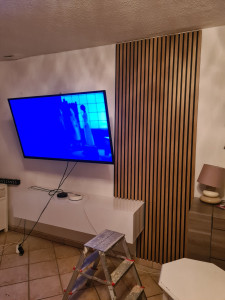 Photo de galerie - Pose d'une télé au mur. Pose d'un meuble tv et panneaux décoratifs mural bois. 