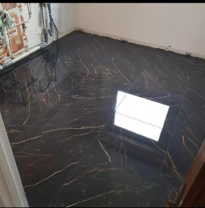 Photo de galerie - Escalier habillé de carrelage imitation marbre blanc aux veinages gris subtils. Les marches aux découpes précises offrent un rendu moderne, lumineux et élégant, mettant en valeur la géométrie de l’escalier