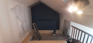 Photo de galerie - Application deux couches peinture teinte un bleu foncé mur et meubles tête de lit