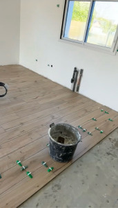 Photo de galerie - Pose de carrelage effet parquet dans grande pièce à vivre + cuisine