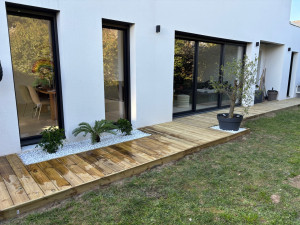 Photo de galerie - Création d’une terrasse autour d’une maison avec jardinière décorative