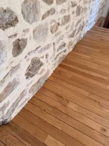 Photo de galerie - Pose parquet collé avec ajustage du mur en pierre 