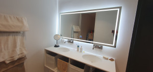 Photo de galerie - Pose de 4 miroirs lumineux dans des salles de bain d'une villa contemporaine.