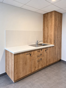 Photo de galerie - Pose d'une kitchenette avec meuble bas,  colonne, plan de travail et évier.