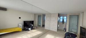 Photo de galerie - Pose de miroirs collés au mur d'un séjour.