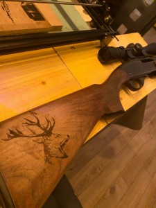 Photo de galerie - Gravure tête de cerf sur une carabine de chasse 