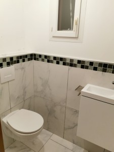 Photo de galerie - Pose d'un WC suspendu avec faïence et un lave main. 