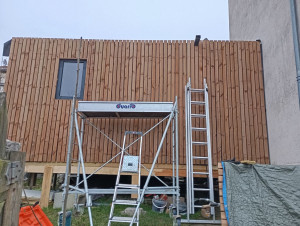 Photo de galerie - Agrandissement d'une maison avec une ossature bois pour une pièce de 20m2 
sur pilotis pour rattraper la hauteur pour l'ouverture l'accès à la pièce.