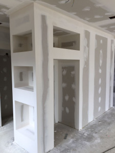 Photo de galerie - Création d'une cloison décorative en plaques de plâtre avec niches intégrées. Réalisation des bandes à joints et préparation des supports avant peinture. Un travail précis alliant esthétique et finitions soignées pour un rendu moderne
