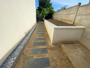 Photo de galerie - Aménagement d’une cour avec muret de soutènement et pas japonais ardoise création escalier et bordure