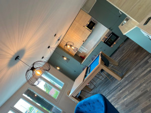 Photo de galerie - Rénovation d’une cuisine ouverte sur le séjour. Aménagement moderne avec meubles de cuisine contemporains, crédence soignée et sol effet bois. Un espace fonctionnel et élégant aux finitions harmonieuses.