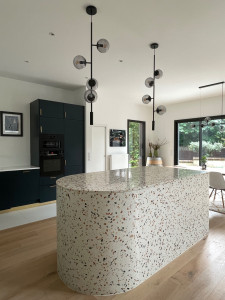 Photo de galerie - Cuisine qui vient s'agencer autour d'un ilot sur mesure en Terrazzo
