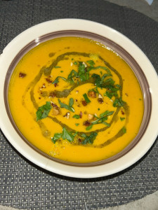 Photo de galerie - Velouté de butternut au lait de coco huile aux herbes fraîches, noisettes concassées 