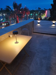 Photo de galerie - L'aspect brut et chaleureux du travertin transforme radicalement l'ambiance de la terrasse. Le contraste entre la pierre claire, le mobilier moderne et la végétation environnante crée un véritable écrin méditerranéen, à la fois chic et accueillant.