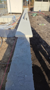 Photo de galerie - Pose du muret en parpaing a bancher plus chapeau .