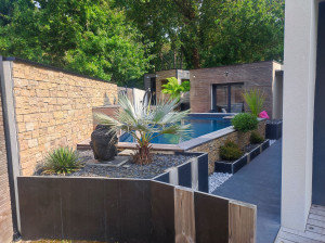 Photo de galerie - Création d'aménagement complet, muret avec enduit et parremant de pierre, jardinier palis d'ardoise et bois allée en dalle 1x1m terrasse bois exotic, maçonnerie 
piscine ect..

