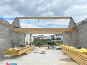 Photo de galerie - Construction des murs en parpaings et pose des poutres de la structure.