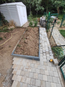 Photo de galerie - Aménagement d'un jardin (potager), réalisation d'allé avec des pavés béton et bordure gris foncé 