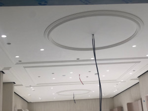Photo de galerie - Création de plafond décoratif haut de gamme : moulures, corniches et intégration d'éclairage spots.