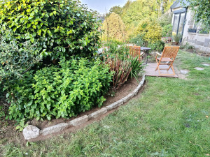 Photo de galerie - Pose d'une petite bordure en granite autour d'un massif et réalisation d'une petite terrasse en bois exotique.