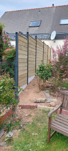 Photo de galerie - Réalisation d'une clôture en panneaux lame bois traité classe 4 et poteaux aluminium RAL 7016