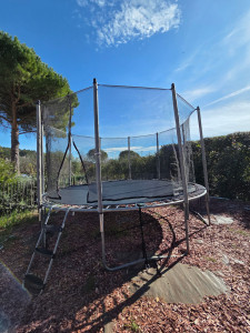 Photo de galerie - Montage et installation d'un trampoline. trampoline ancré au sol par des plots béton. 