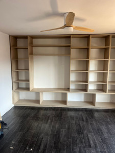 Photo de galerie - Création d'une bibliothèque dans un salon pour recevoir livre ,objet de décoration et tv qui sera accroché ,vu avec la cliente pour les étagère 