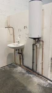 Photo de galerie - Installation sanitaire réalisée dans le cadre de ma formation en plomberie. Pose d’un lavabo et d’un chauffe-eau avec raccordements eau chaude et eau froide. Travail propre et soigné. 